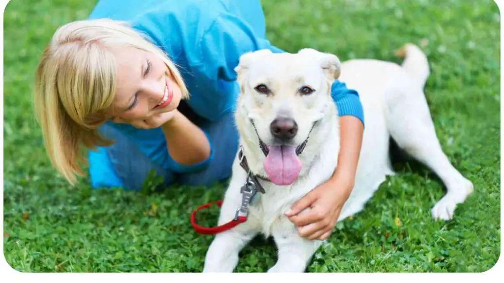 a person laying on the grass with their dog