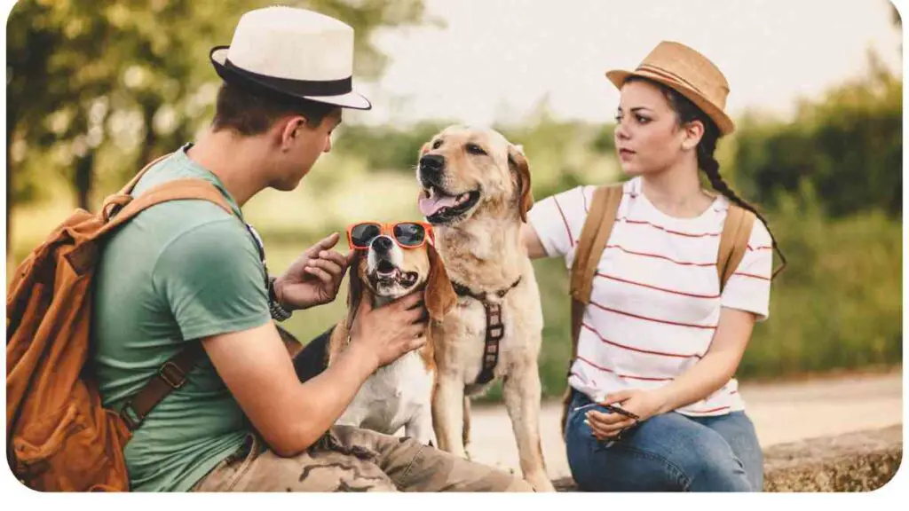 Two people are sitting on the ground with a dog